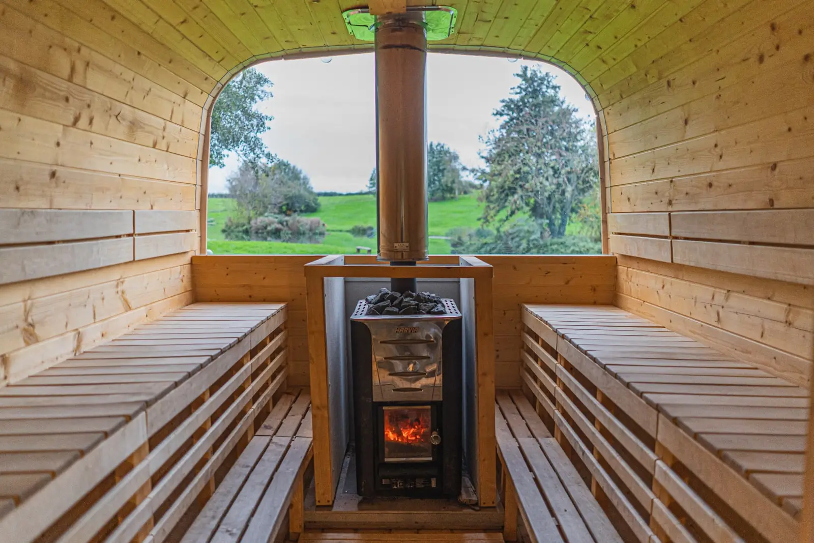 Inside the Suvi Ross-on-Wye sauna: benches on both sides of the wood-fired stove